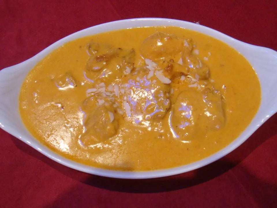 Poulet shahi korma dans une sauce crémeuse aux amandes, servi en plat ovale.